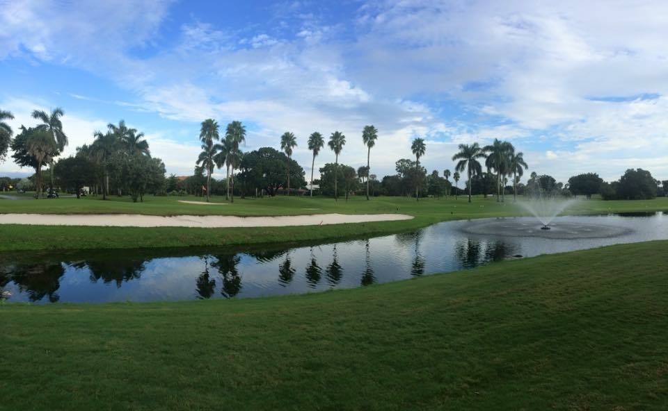 Pond on golf course with path in distance