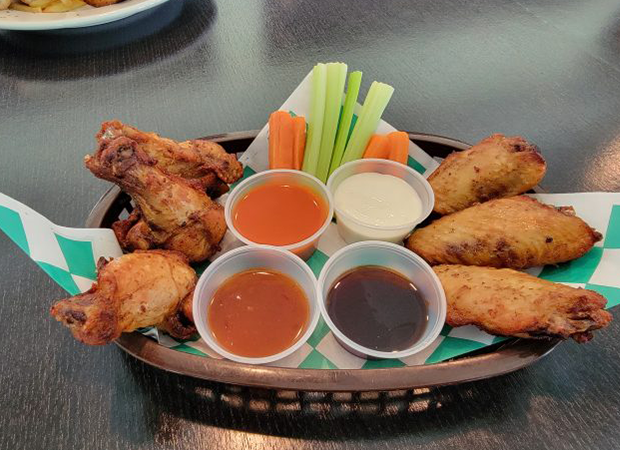Basket of wings with sauces, carrots, and celery